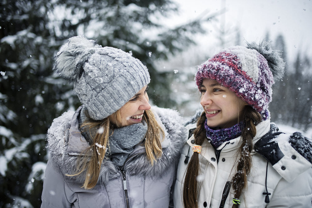 Mother and daughter walking on snowy day