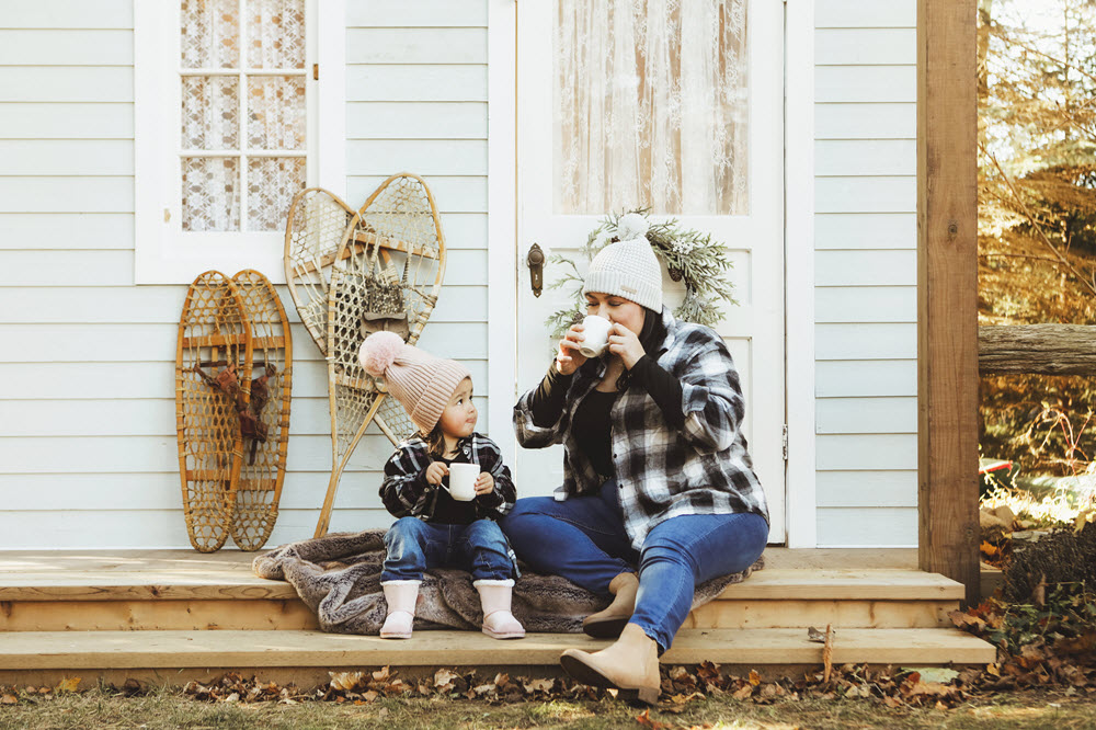 Mother and small child drinking from mugs