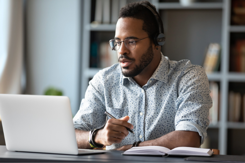Man at computer writing notes